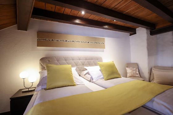 De hotelkamer in het Hotel Auberge Aal Veinen Beim Hunn in Vianden. De rustieke kamer is voorzien van een hotelbed met een gele deken en is liefdevol ingericht.De hotelkamer in het Hotel Auberge Aal Veinen Beim Hunn in Vianden. De rustieke kamer is voorzien van een hotelbed met een gele deken en is liefdevol ingericht.