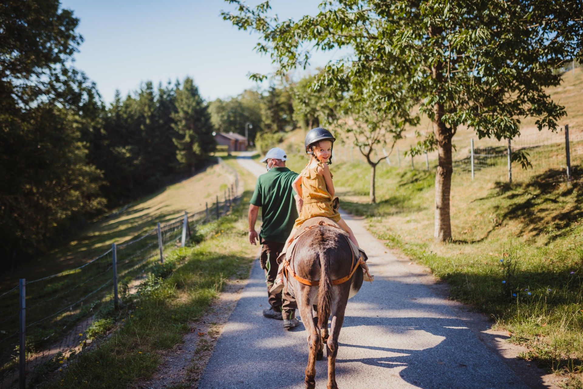 Child leading a donkey along a rural path at Robbesscheier in Munshausen