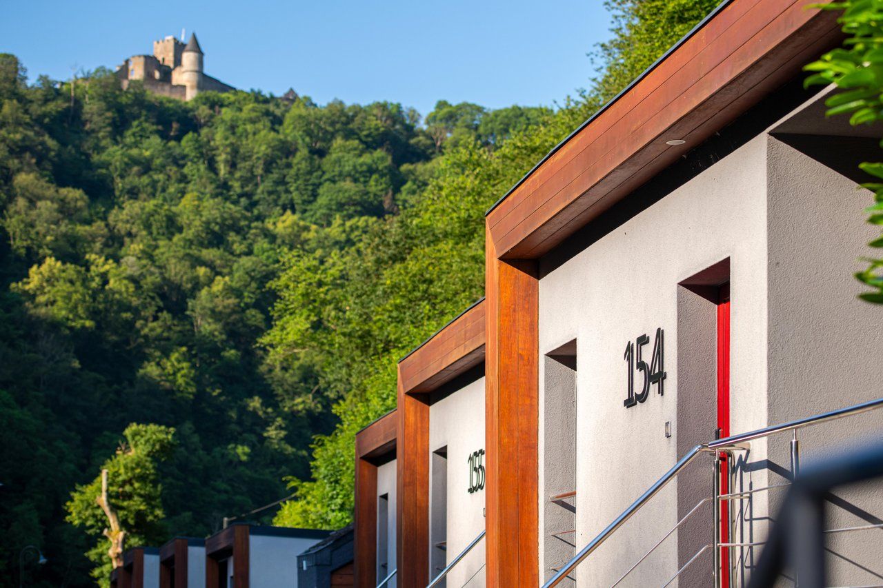 Summer outdoor views of holiday appartments onto Bourscheid Castle