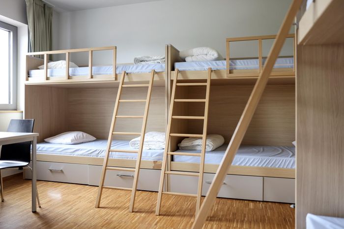 Une chambre de l’auberge de jeunesse de Weicherdange avec des lits superposés en bois massif et un aménagement simple.