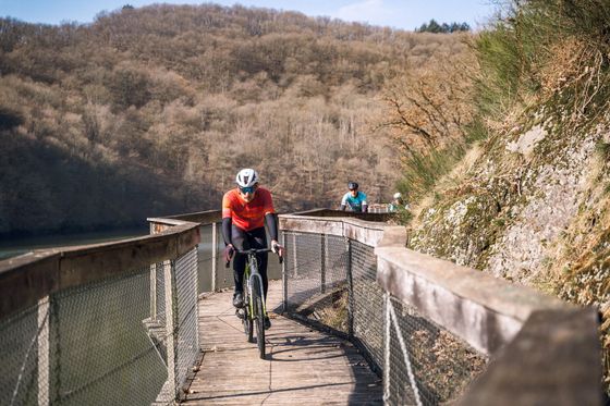 Cyclistes gravel roulant sur la promenade de l’Ourdall près de Vianden, dans l’Éislek, au Luxembourg.