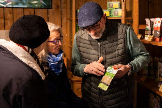 People looking at and discussing a local food product inside a shop