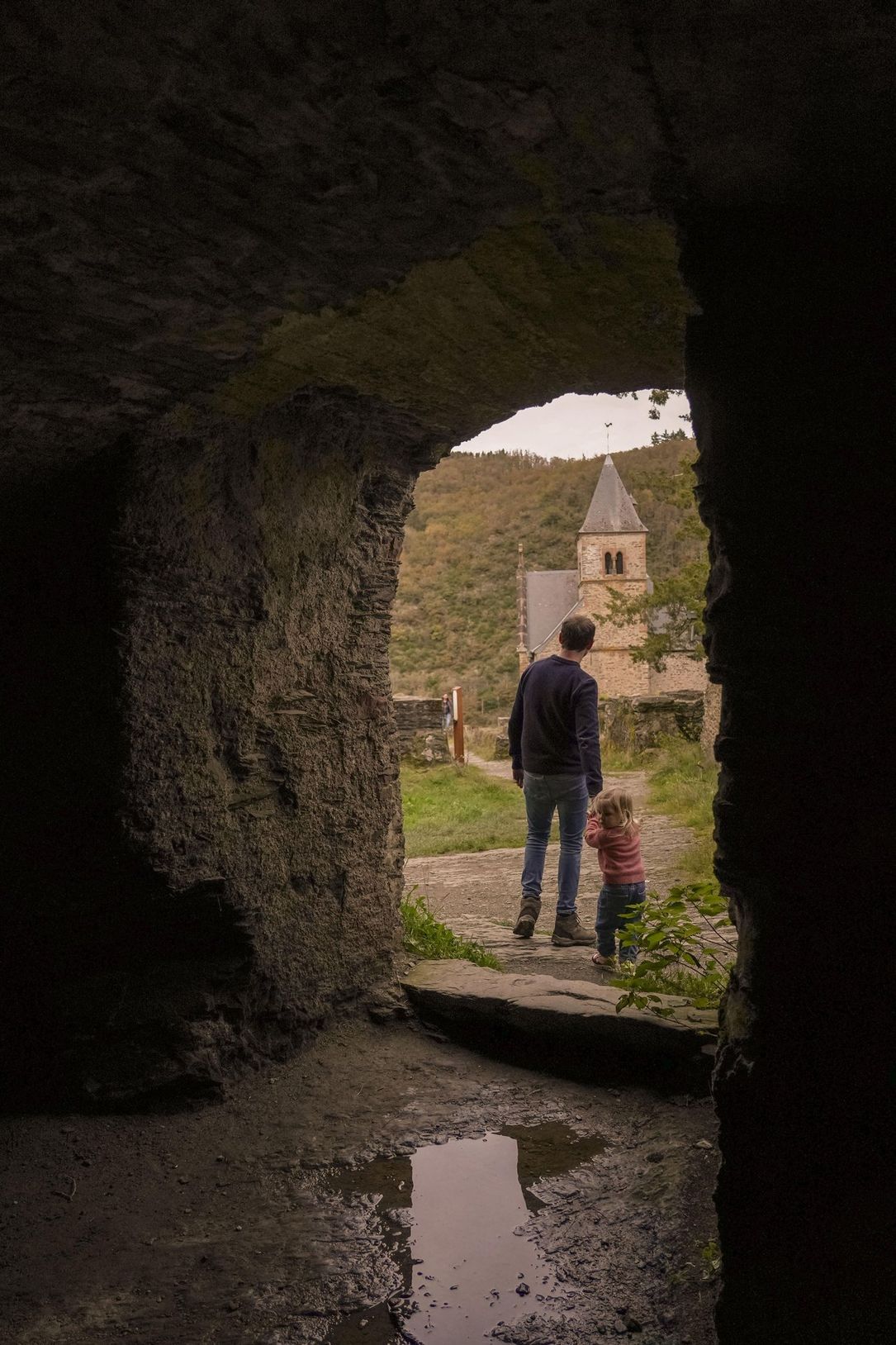 Dad and toddler exploring the ruins of Esch-sur-Sûre Castle in Éislek, Luxembourg, during autumn. 