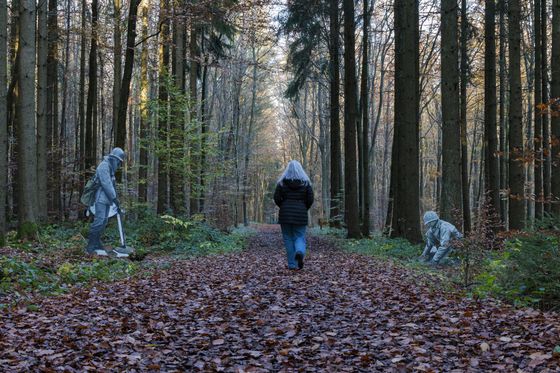 Femme marchant sur le sentier mémoriel de Schumannseck dans l’Éislek, au Luxembourg, entourée de couleurs automnales.