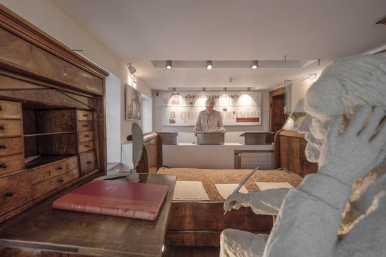 Tentoonstellingsruimte in het Victor Hugo Museum in Vianden met schrijftafel, historisch meubilair en beeld van Victor Hugo