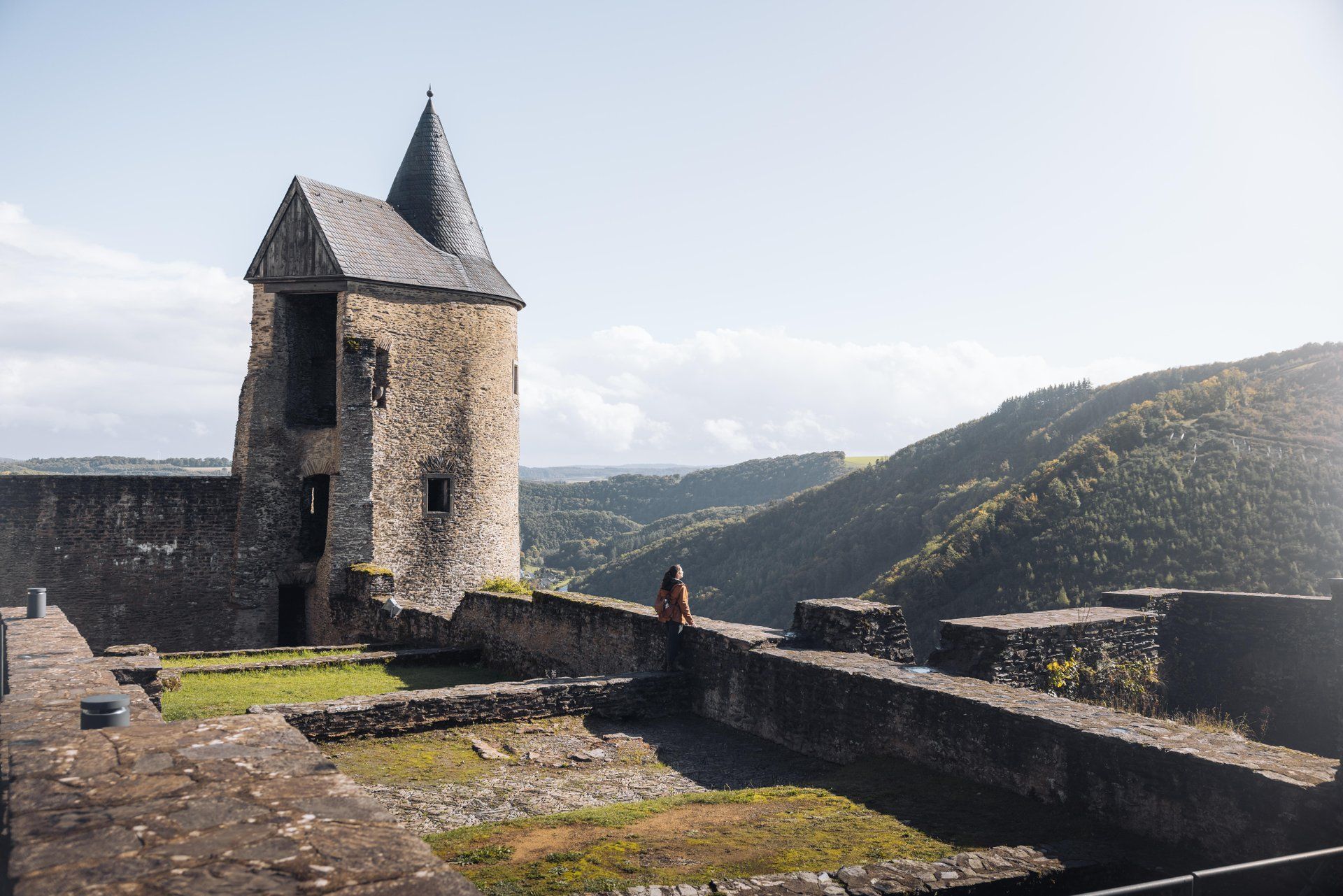Bourscheid Castle with tower and walls overlooking the surrounding hilly landscape in Éislek