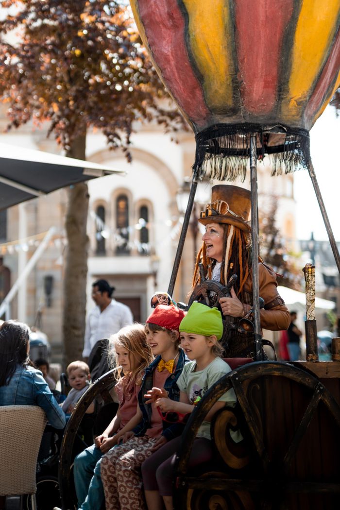 Kinder sitzen in einem gebastelten Heißluftballon während des Wichtelfestes in Ettelbruck und erleben kreative Spielaktionen.