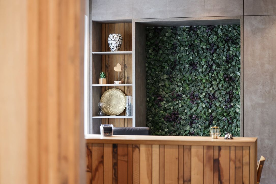 A modern reception area with wooden walls and stylish decor at the Hotel Terrace in Bettendorf.