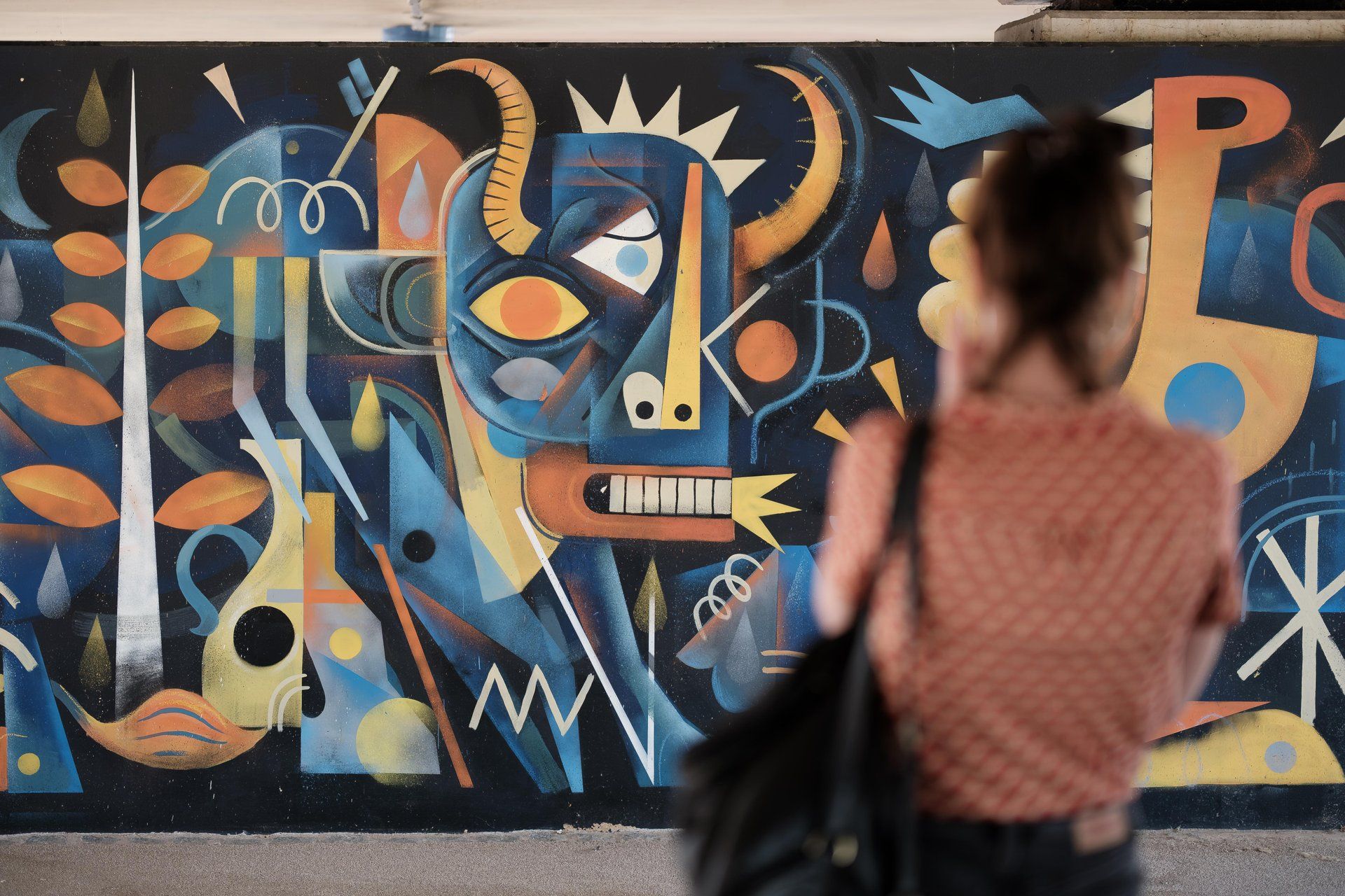 Persoon voor een kleurrijke streetartmuur in Ettelbruck