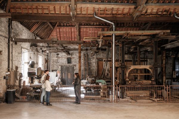 Un couple visite le musée de l’ardoise à Haute Martelange et reçoit des explications d’un guide sur l’exposition.