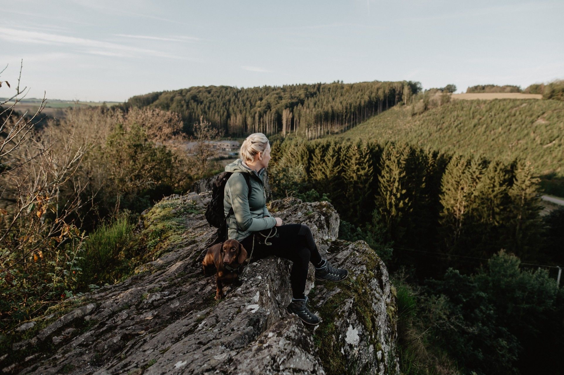 Woman enjoying the panoramic view from the Sideschlee viewpoint in Troisvierges on the Escapardenne Éislek Trail, Luxembourg.